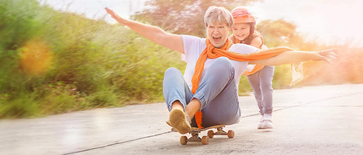 Älterer Mensch und Kind skateboarden gemeinsam.