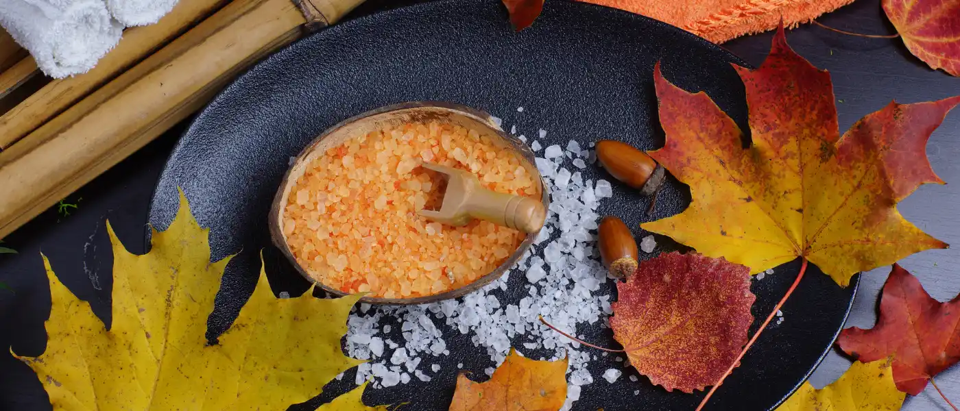 Herbstdeko mit bunten Blättern und Badesalz.